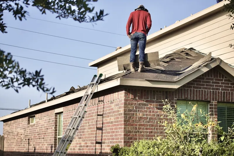 Professional roofer working on a residential roof in Naushon Station